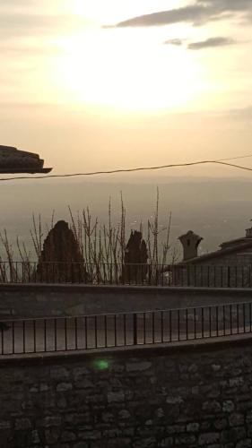 a view of the ocean at sunset from a fence at Apartments Aurora Delle Rose in Assisi