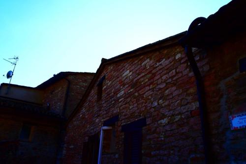 a brick building with a sign on the side of it at Apartments Aurora Delle Rose in Assisi