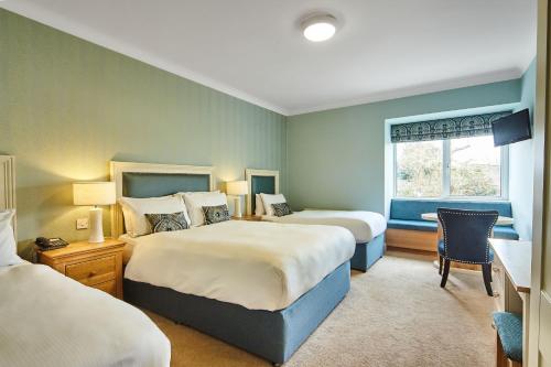 um quarto de hotel com duas camas e uma janela em The Farmers Kitchen Hotel em Wexford
