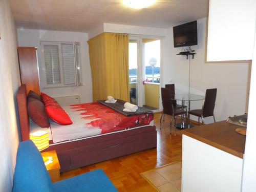 Un dormitorio con una cama con almohadas rojas y una mesa. en Sea View Apartment, en Cavtat
