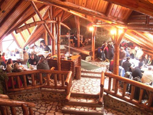 a group of people sitting at tables in a building at Resort Cheile Gradistei Moieciu in Moieciu de Sus