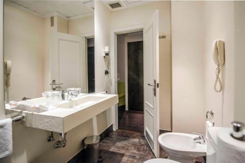 a bathroom with a sink and a toilet at Hotel Conde Duque Bilbao in Bilbao