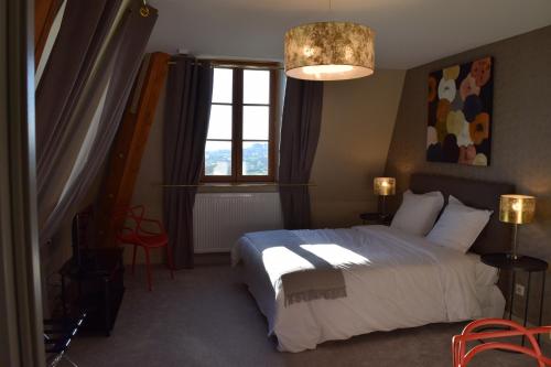 a bedroom with a large bed and a window at Hotel La Croix De Vernuche in Varennes Vauzelles