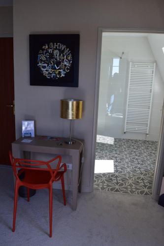 a room with a desk and a chair and a lamp at Hotel La Croix De Vernuche in Varennes Vauzelles