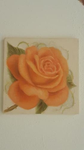 a painting of a orange rose on a plate at Five Roses Bed & Breakfast in Pisa