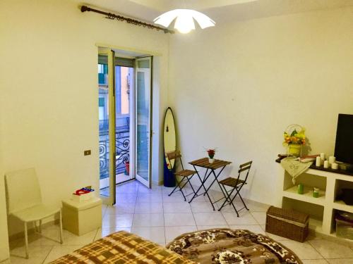 ナポリにあるMiseria e Nobiltà Apartment CHECK-IN FROM 12 00 TO 15 00のベッド、テーブル、椅子が備わる客室です。