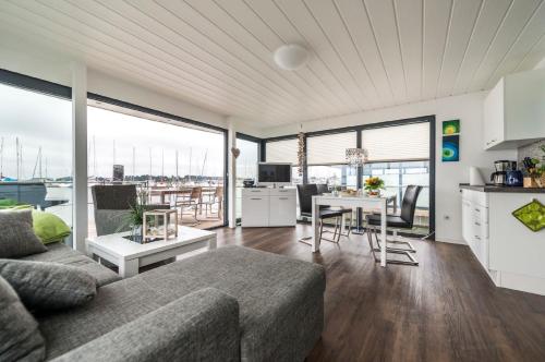 a living room with a couch and a table at Hausboot FJORDBLIK in Kollund Østerskov