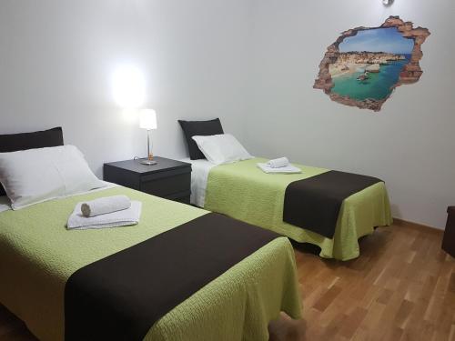 Zimmer mit 2 Betten und einem Wandspiegel in der Unterkunft Villa Oliveira Apartments in Lagos