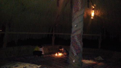 a couple of people sitting around a fire at night at SakraTah Camp - eco friendly in Taba