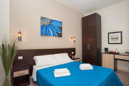a bedroom with a blue bed with two towels on it at Flowerome in Rome