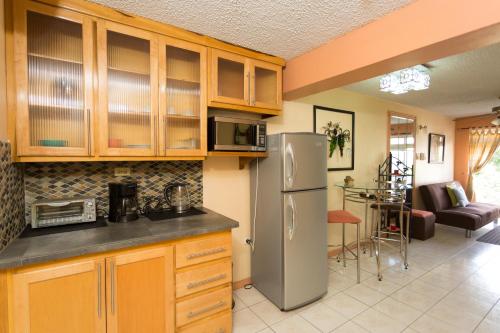 una cucina con mobili in legno e un frigorifero in acciaio inossidabile di Cozy Accommodations a Kingston