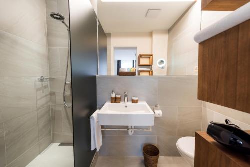a bathroom with a sink and a shower at Boutique Hotel NI-MO in Zürich