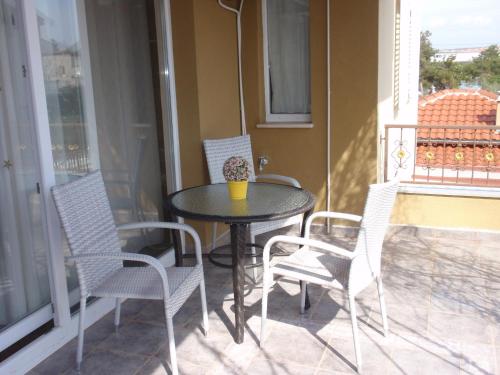 uma mesa e cadeiras numa varanda com uma mesa e cadeiras em Apartment Vera em Zadar
