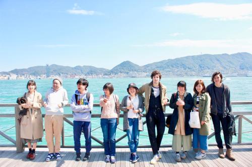 a group of people standing on a pier near the water at Hostel TangaTable in Kitakyushu