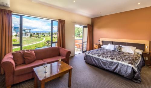une chambre d'hôtel avec un lit et un canapé dans l'établissement Waterfront motel, à Blenheim