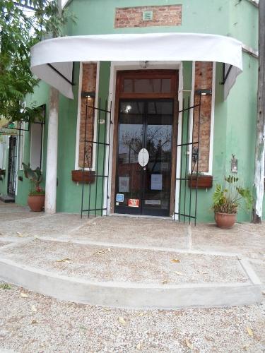 an entrance to a green building with a glass door at La Casona de Susana in Colón