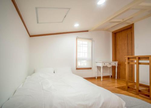 Tempat tidur dalam kamar di Jeju Nolmung