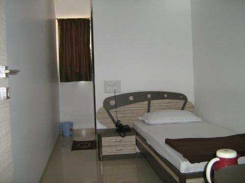 a small bedroom with a bed in a room at Hotel Apex in Navi Mumbai