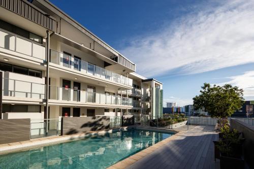 an apartment building with a swimming pool in front of it at Central Islington Apartments in Townsville