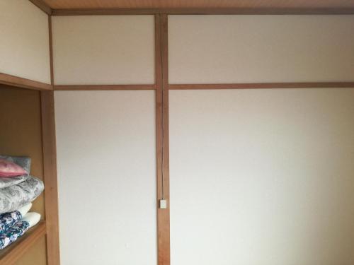 a closet with white doors in a room at Shoei backpackes hostel in Teshikaga