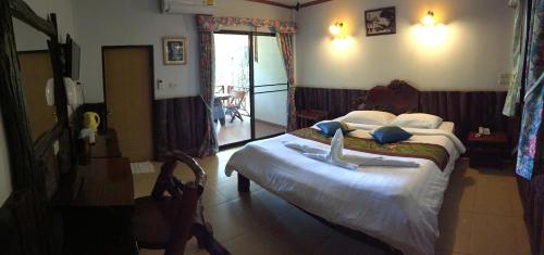 a bedroom with a large bed in a room at Saiyok River House in Sai Yok