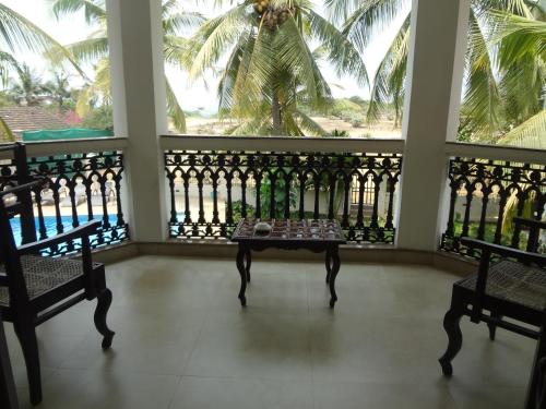 einen Tisch in der Mitte eines Zimmers mit Fenstern in der Unterkunft Resort Coqueiral in Candolim
