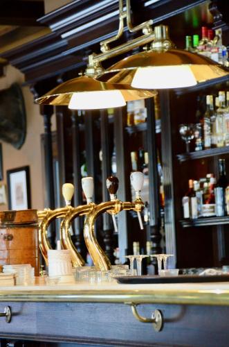 a gold bar with a mirror behind a counter at Le Baron Apartments in Stavelot