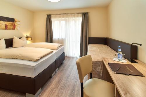 a hotel room with a bed and a table and a desk at Gasthof Gigl in Neustadt an der Donau