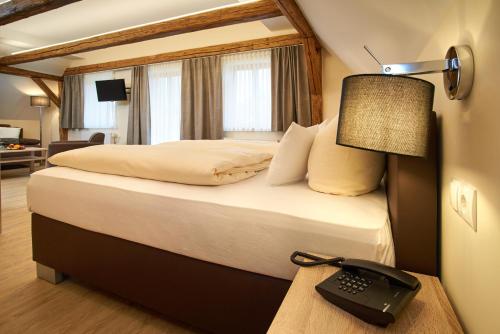 a hotel room with a bed with a lamp and a desk at Gasthof Gigl in Neustadt an der Donau