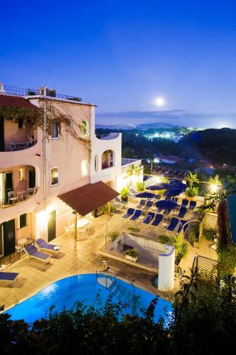 a hotel with a swimming pool and lounge chairs at Hotel Bellevue Benessere & Relax in Ischia