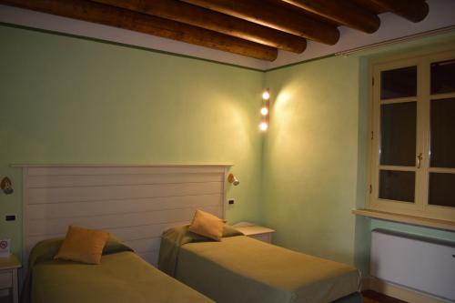 a bedroom with two beds and a window at Agriturismo Cà Del Lupo in Palazzolo sullʼOglio