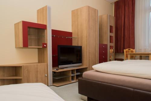 a room with two beds and a flat screen tv at Welog Rast Ilz in Ilz