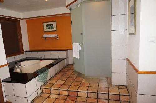 a bathroom with a tub and a sink at Wonderland Private Chalet at Port Dickson in Port Dickson
