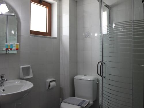 a bathroom with a toilet and a sink and a shower at Vallian Village Hotel in Paradeísion