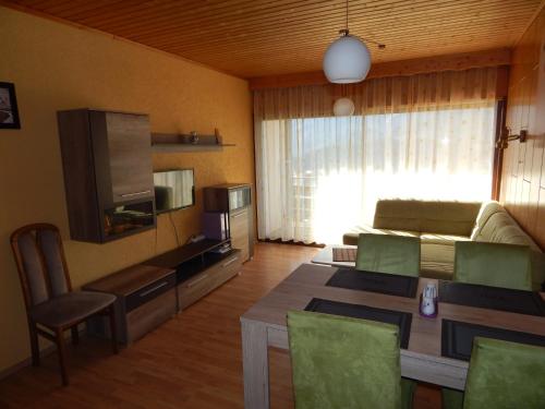 a living room with a couch and a table and a television at Appartement Bergblick in Tauplitz