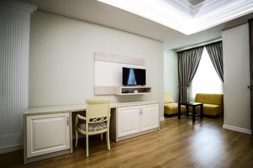 エルバサンにあるHotel Vila Imperialのテーブルとテレビのあるリビングルーム