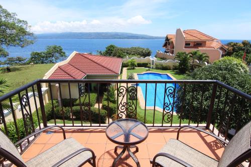 a balcony with chairs and a view of a house at Star View Boutique Resort in Dumaguete