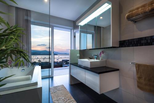 a bathroom with two sinks and a tub and a mirror at Sunset Sea View Apartment in Bang Rak Beach