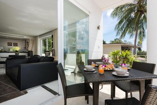 una sala da pranzo e un soggiorno con tavolo e sedie di Sunset Sea View Apartment a Bangrak Beach