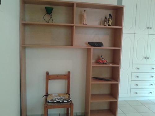 パトラにあるThomais Apartmentの木製の椅子付きの部屋の本棚