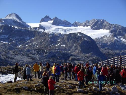 a group of people standing in front of a mountain at Haus Alpenrose in Obertraun