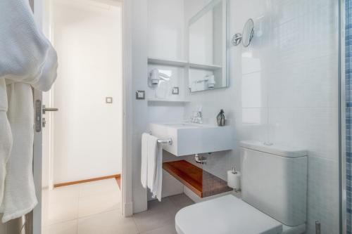 a white bathroom with a sink and a toilet at Hotel LIVVO Los Calderones - Adults recommended in Maspalomas