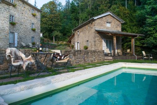 a house and a swimming pool in front of a house at SASSO AL MELO - Apartments in Cutigliano