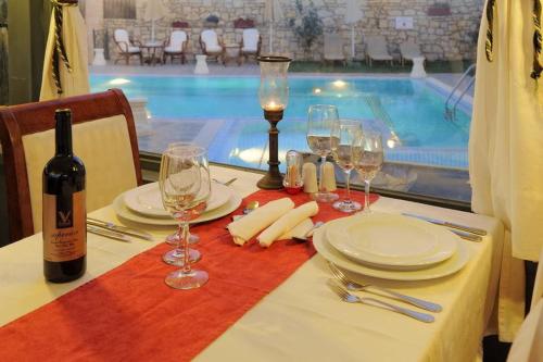 a table with glasses and a bottle of wine next to a pool at Vergis Epavlis in Agios Myronas