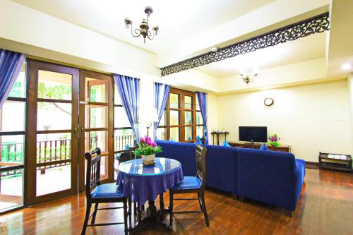 a living room with a blue couch and a table at Shewe Wana Suite Resort in Chiang Mai