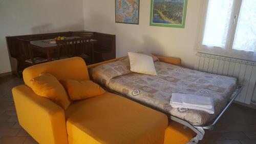 a bed and a chair in a room at B&B Podere Montese in Villafranca in Lunigiana