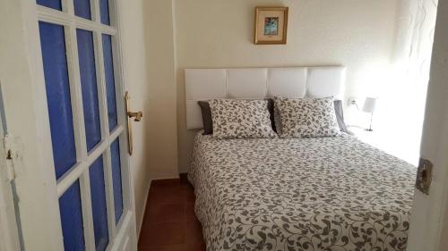 a bedroom with a bed and a window and a door at En el Corazón de Sevilla in Seville