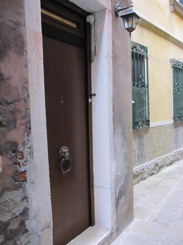 a brown door on the side of a building at Ca' Malatin in Venice