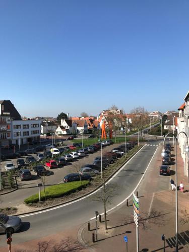 a city street with cars parked in a parking lot at Sunny Home in Knokke-Heist