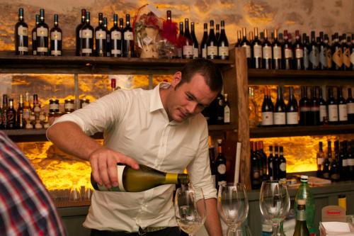 a man pouring wine into a glass in a bar at Borgo San Valentino in Arrone